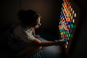 Enfant explorant l'espace sensoriel Snoezelen avec jeux de lumières et textures à La Bulle du Bien-Naître, Bois-Guillaume
